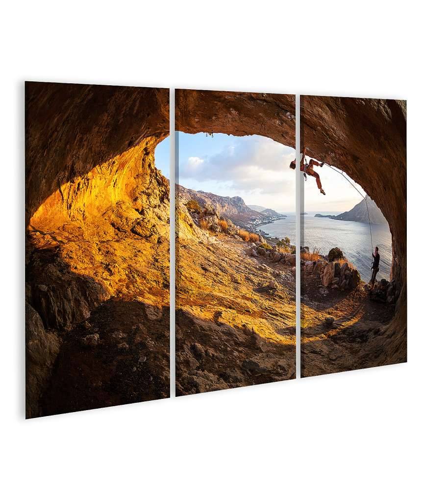 Islandburner Bild auf Leinwand Junge Frau klettert in Höhle mit atemberaubender Aussicht im Hintergrund Outlet